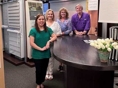 Dealership staff standing at a desk, smiling at the camera